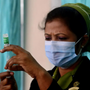 Woman health worker in Bangladesh fills a syringe