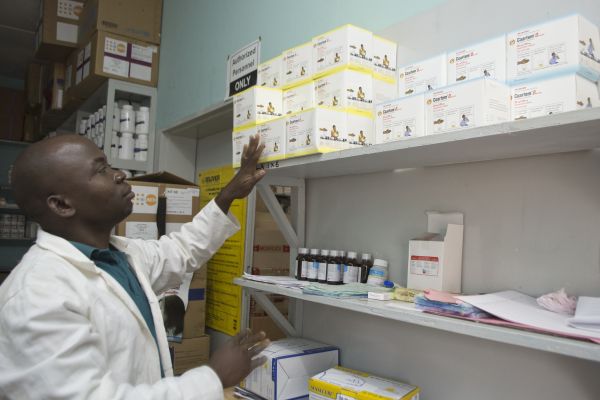 A pharmacist examines available medicines in Malawi.