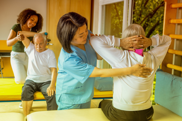 A man and a woman receive rehabilitation from healthcare workers
