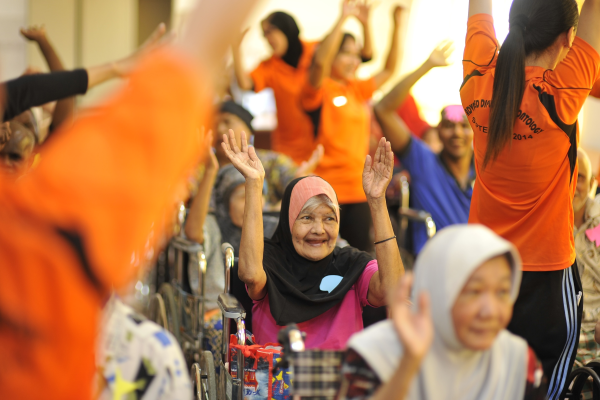 Old people exercising with nurses to maintain good mental and physical health