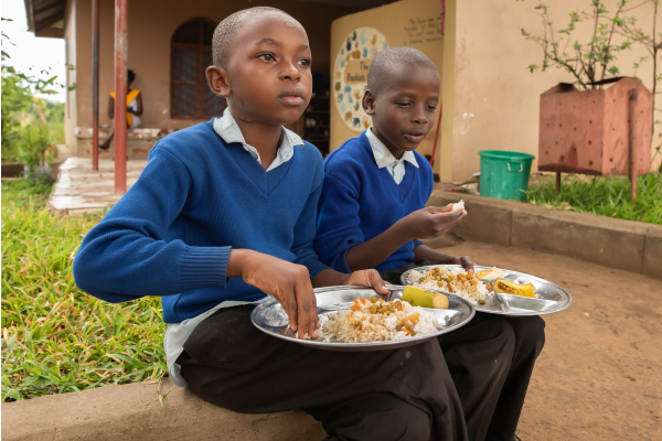 Two children eating at a school in Tanzania