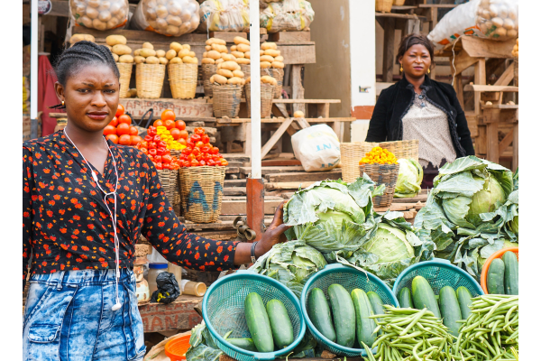 Two women selling vegetables in a food market in Nigeria